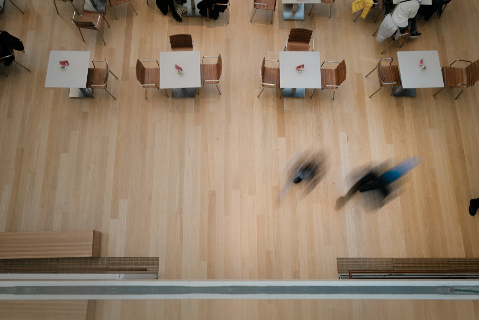 A room of tables with people moving between them, seen from above